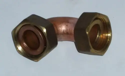 Rücklaufrohr mit gewinkeltem Design, aus Kupfer und Messing, geeignet für Daikin Rotex GW T-Modelle bis Baujahr 2019, ohne sichtbare Beschriftungen oder Maße.